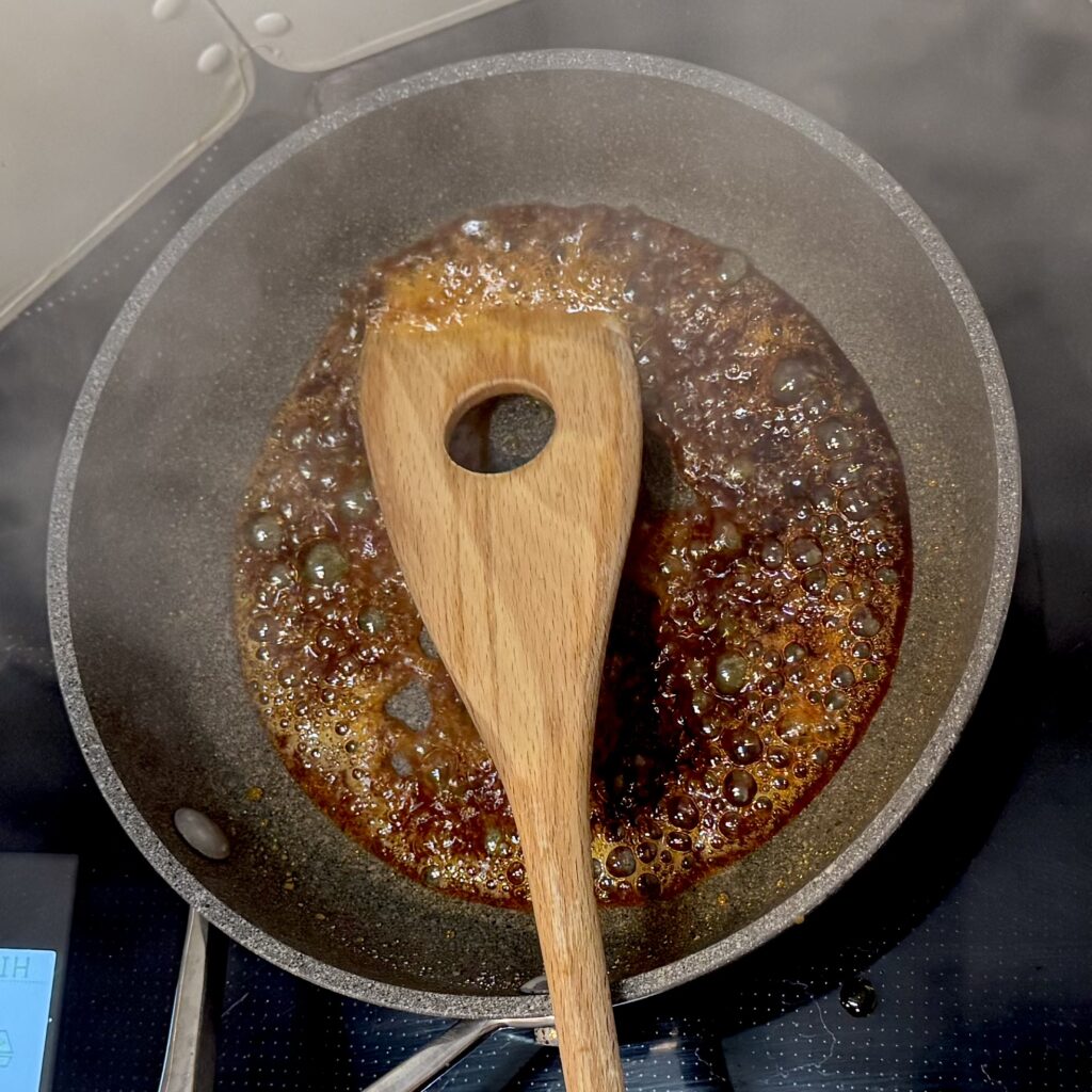 プリン用カラメル作りの工程。飴色になったカラメルを火から下ろして、お湯を加えた後の様子。